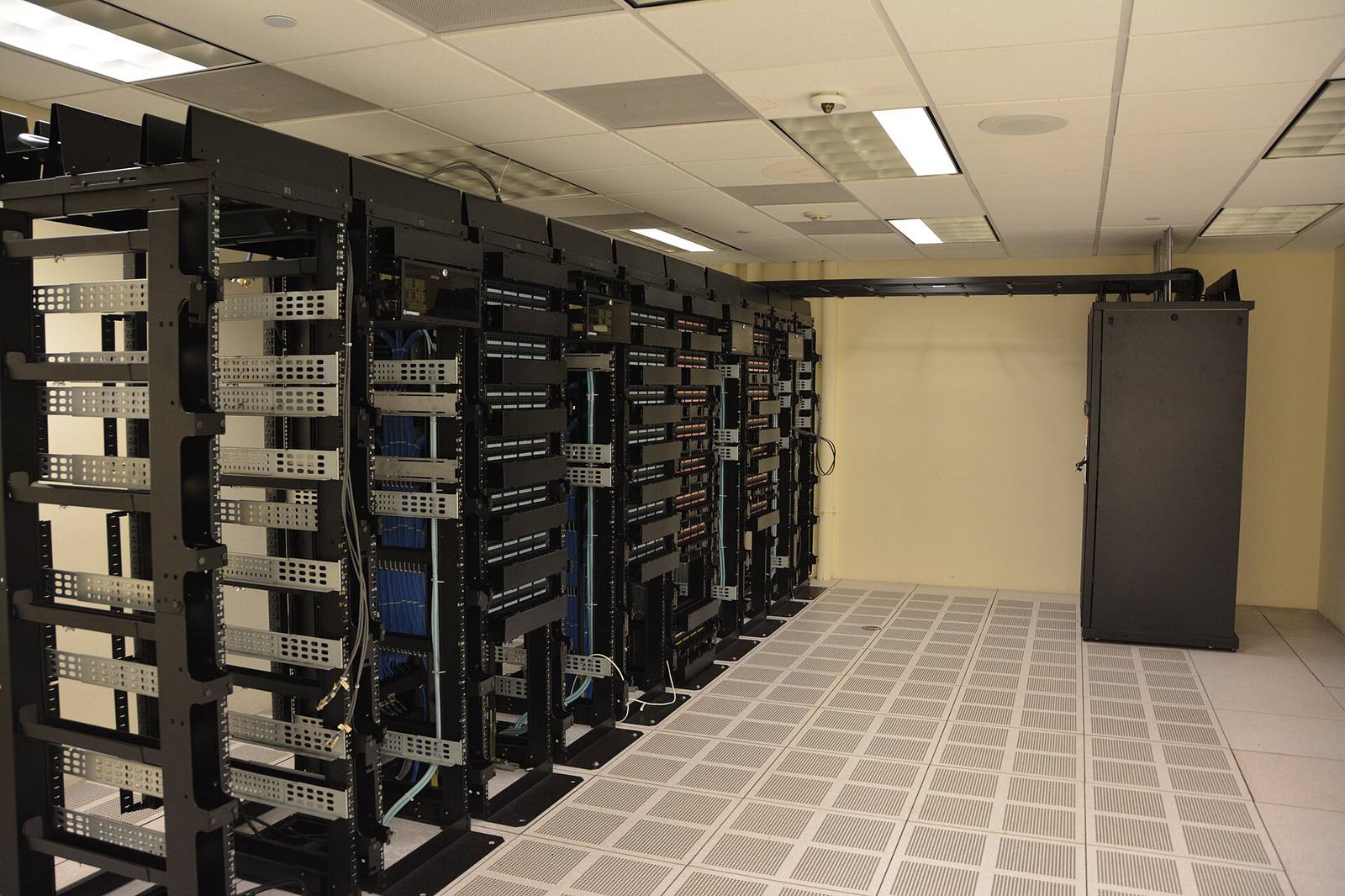 Sala de servidores genérica com racks e cabeamento azul, o tipo de infraestrutura que você não precisa alugar. Foto: Carl Lender / Wikimedia Commons, CC BY 2.0