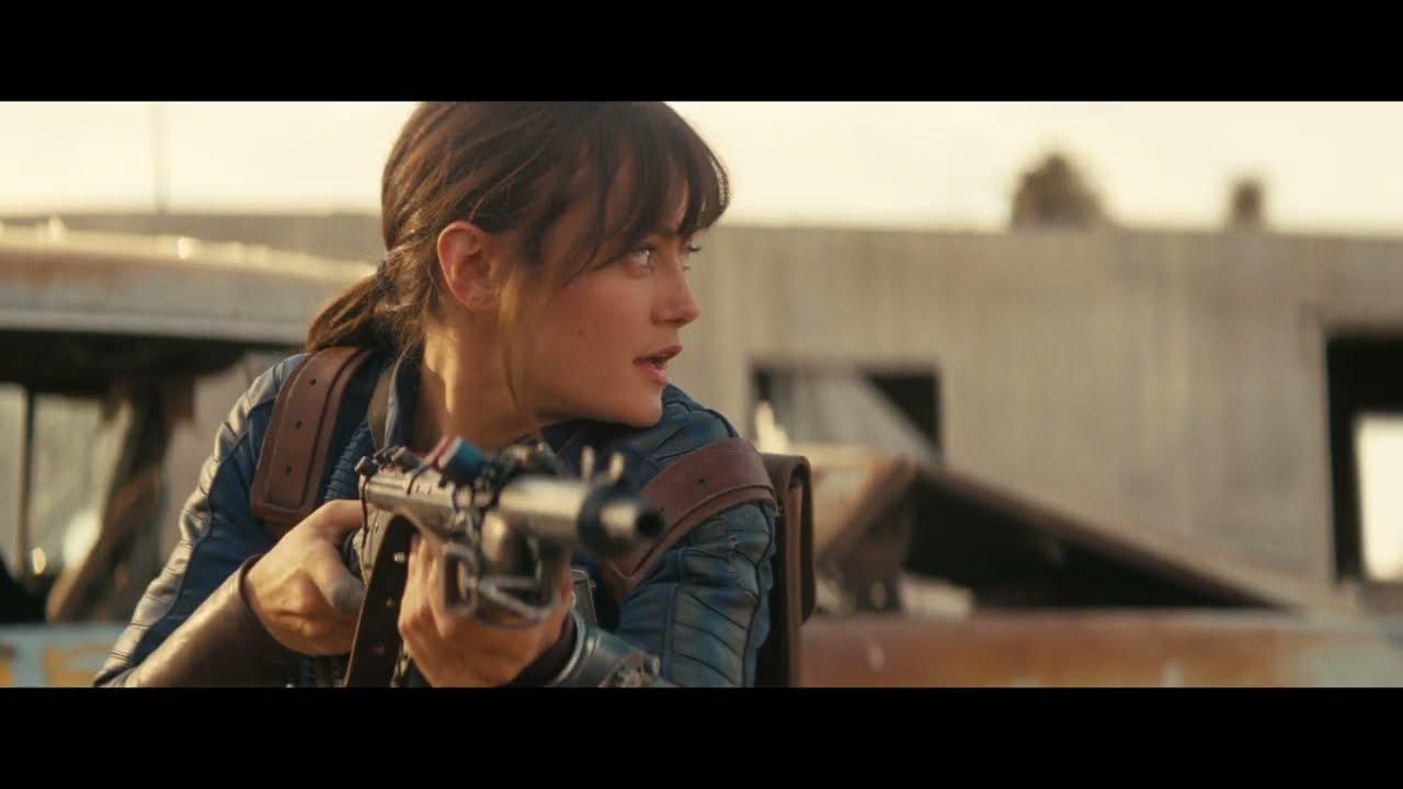 Lucy MacLean no deserto com rifle, com figuras blindadas ao fundo — Divulgação: Prime Video
